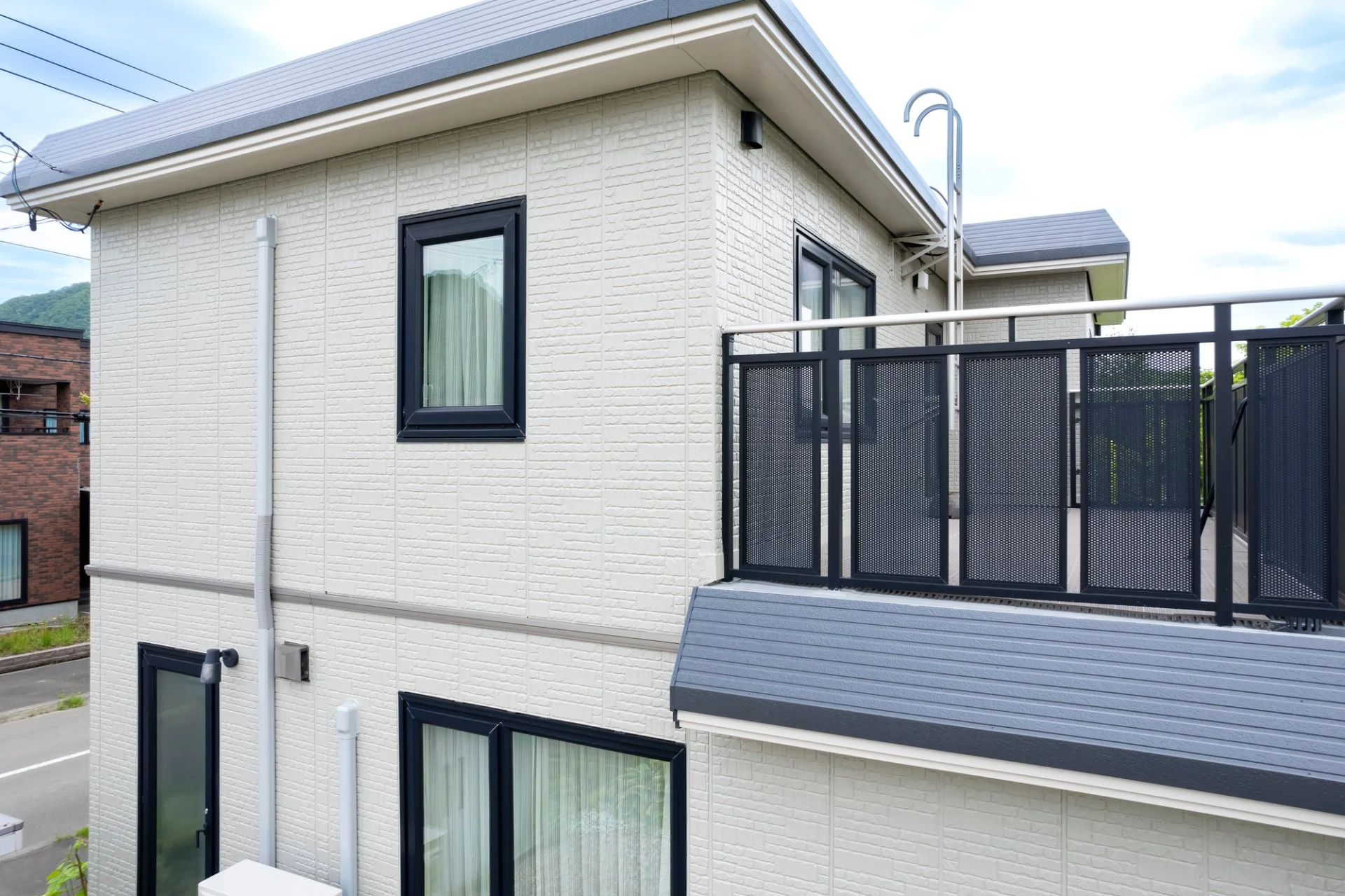 集合住宅の共用廊下で手すりとドアクローザーを調整し終えた直後の通路写真